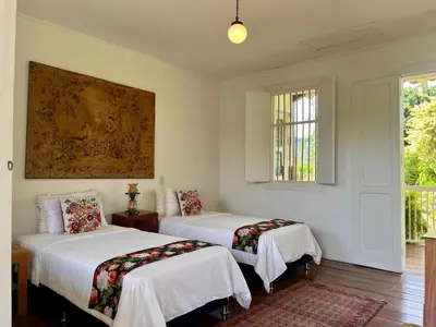 two beds in a room with white walls at Hacienda El Rosario Manizales in Manizales