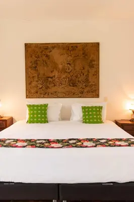 a bedroom with a bed with two green pillows at Hacienda El Rosario Manizales in Manizales