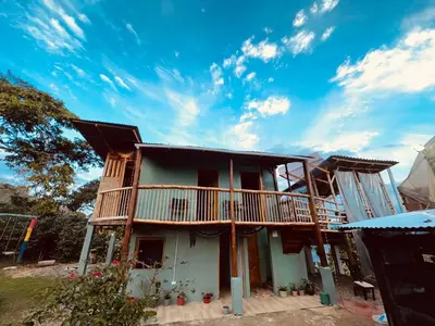 a house with a balcony on top of it at Titiribi-Antioquia- Cabaña el sol in Titiribí