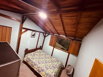 a bedroom with a bed in a room with wooden ceilings at Titiribi-Antioquia- Cabaña el sol in Titiribí