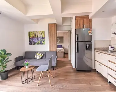 a kitchen and living room with a couch and a table at Amazing view - Poblado in Medellín