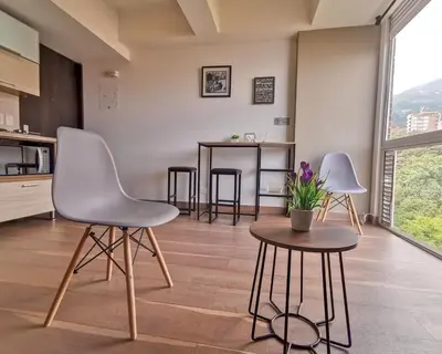 two white chairs and a table in a kitchen at Amazing view - Poblado in Medellín