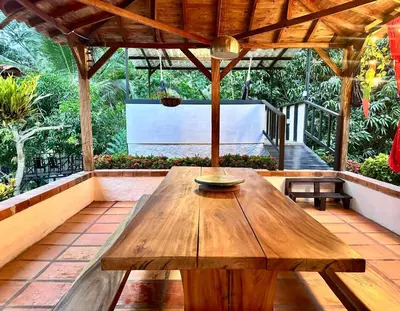 a wooden table on a patio with a screen at Casa Verano la rumbita Naturaleza, Piscina y Rio in Santa Fe de Antioquia