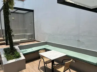 a patio with a green bench and a table and chairs at Hotel 79 Poblado in Medellín