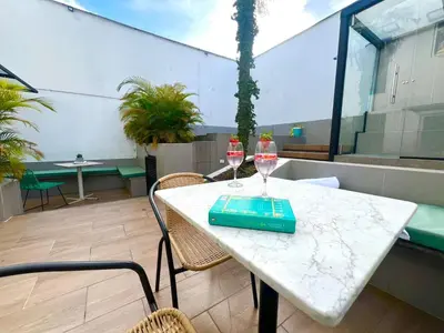 a table with two wine glasses on a balcony at Hotel 79 Poblado in Medellín