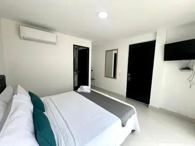 a bedroom with a white bed and two windows at Hotel 79 Poblado in Medellín