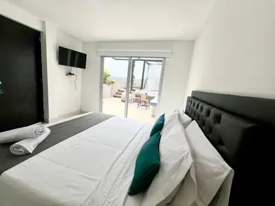 a bedroom with a large white bed with a green pillow at Hotel 79 Poblado in Medellín