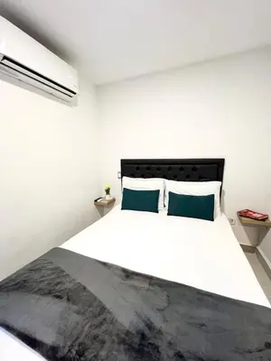 a bedroom with a large white bed with blue pillows at Hotel 79 Poblado in Medellín