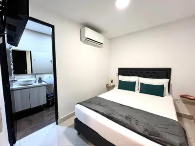 a bedroom with a bed and a bathroom with a sink at Hotel 79 Poblado in Medellín