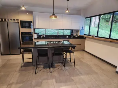 a kitchen with a table and some chairs in it at lujosa villa campestre in Girardota