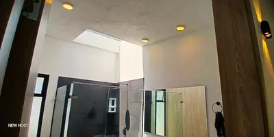 a bathroom with a glass shower and a mirror at lujosa villa campestre in Girardota