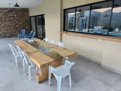 a large wooden table and chairs in a room at lujosa villa campestre in Girardota