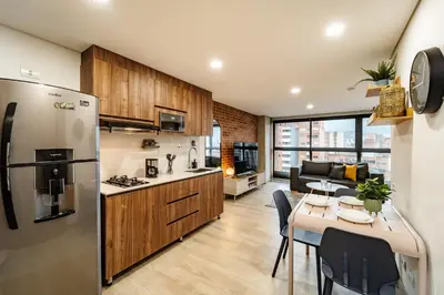 a kitchen and living room with a stainless steel refrigerator at MEDELLIN LAURELES POR DÁS in Medellín