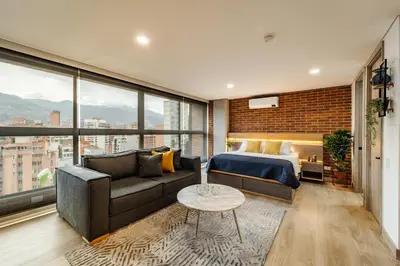a bedroom with a couch and a bed and a window at MEDELLIN LAURELES POR DÁS in Medellín
