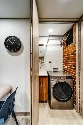a washing machine in a room with a clock on the wall at MEDELLIN LAURELES POR DÁS in Medellín
