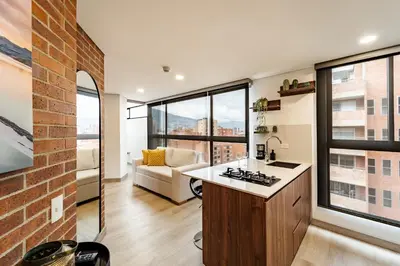 a kitchen and living room with a brick wall at MEDELLIN LAURELES POR DÁS in Medellín