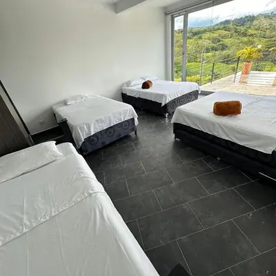 three beds in a room with a large window at XDfinca in Palermo