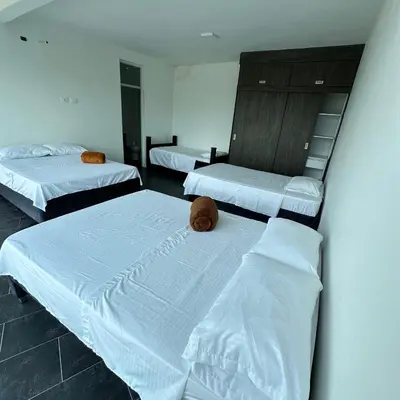 a room with three beds with white sheets and aigilinylinylinylinylinyl at XDfinca in Palermo