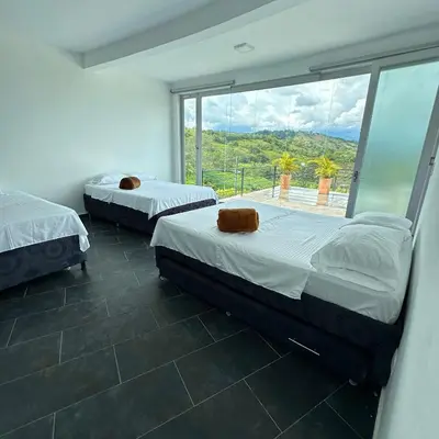 two beds in a room with a large window at XDfinca in Palermo