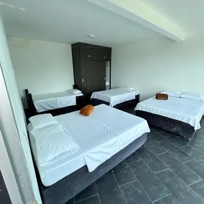 three beds in a room with white walls at XDfinca in Palermo