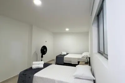 a white room with two beds and a fan at Casa Eternal Comfort and Style in Envigado