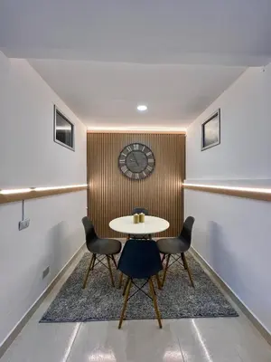 a table and chairs in a room with a clock on the wall at Casa Eternal Comfort and Style in Envigado