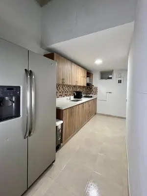 a kitchen with stainless steel refrigerator and wooden cabinets at Casa Eternal Comfort and Style in Envigado