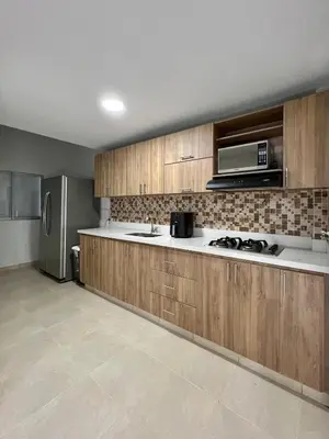 a kitchen with wooden cabinets and a stainless steel refrigerator at Casa Eternal Comfort and Style in Envigado