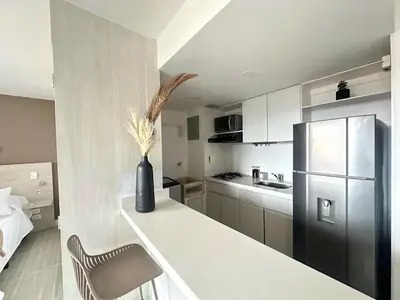 a kitchen with a refrigerator and a vase with flowers at Ac, fast wifi 400 mg, quiet, nature in El Poblado in Medellín
