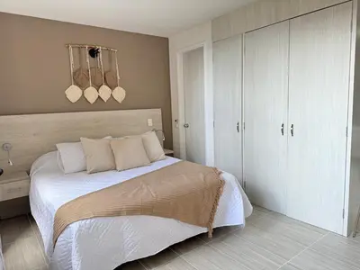 a bedroom with a large bed with white cabinets at Ac, fast wifi 400 mg, quiet, nature in El Poblado in Medellín