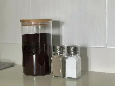two glass bottles and a jar of spices on a counter at Ac, fast wifi 400 mg, quiet, nature in El Poblado in Medellín