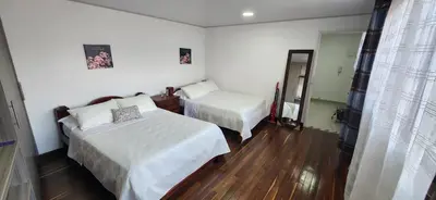 a hotel room with two beds and a mirror at Casa Laureles 2do Parque in Medellín