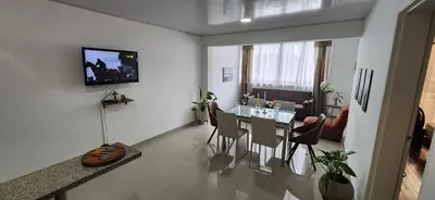 a living room with a table and a dining room at Casa Laureles 2do Parque in Medellín