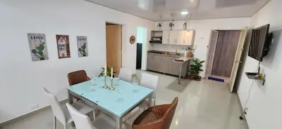 a kitchen and a dining room with a table and chairs at Casa Laureles 2do Parque in Medellín