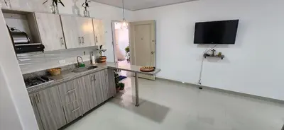 a kitchen with a sink and a tv on the wall at Casa Laureles 2do Parque in Medellín