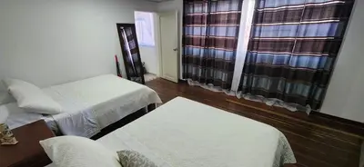 a living room with two beds and a table at Tu casa en Laureles in Medellín