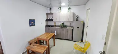 a small kitchen with a table and a refrigerator at Tu casa en Laureles in Medellín