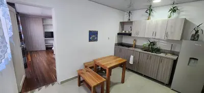 a small kitchen with a wooden table and a counter at Tu casa en Laureles in Medellín