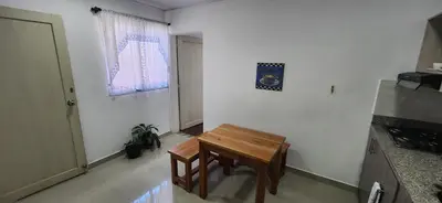 a kitchen with a wooden table in a room at Tu casa en Laureles in Medellín