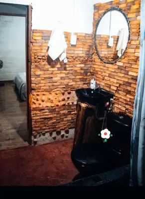 a bathroom with a black sink and a mirror at Hostal otro cuento in Cisneros
