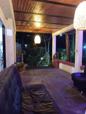a living room with a couch on a patio at night at Hostal otro cuento in Cisneros
