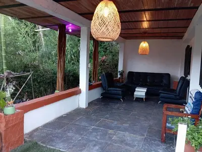 a patio with chairs and a couch on a porch at Hostal otro cuento in Cisneros