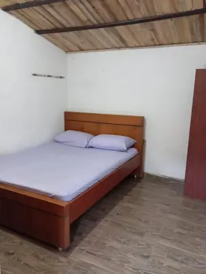 a bedroom with a bed with a wooden headboard at Hostal otro cuento in Cisneros