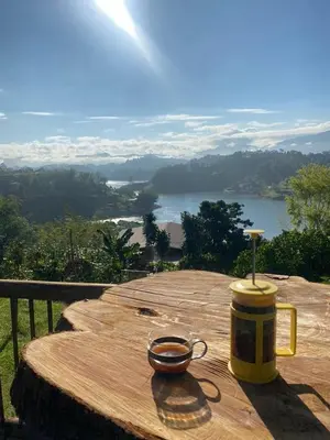 a cup on a wooden table with a view of a lake at Cabaña de cuento in Horizonte