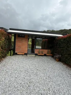 a house with a gravel driveway in front of it at Suites del Lago in Marinilla