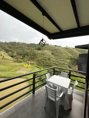 a white table and chairs on a balcony with a view at Suites del Lago in Marinilla