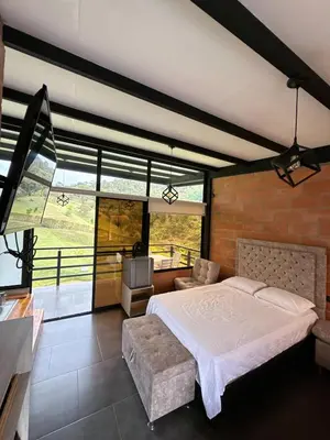 a bedroom with a large bed and a large window at Suites del Lago in Marinilla