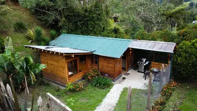 a small wooden house with a tin roof at KITE KIWE LODGE - Parque Arvi in Guarne
