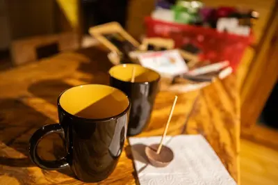 two black coffee cups sitting on a table at KITE KIWE LODGE - Parque Arvi in Guarne