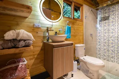 a bathroom with a sink and a toilet at KITE KIWE LODGE - Parque Arvi in Guarne